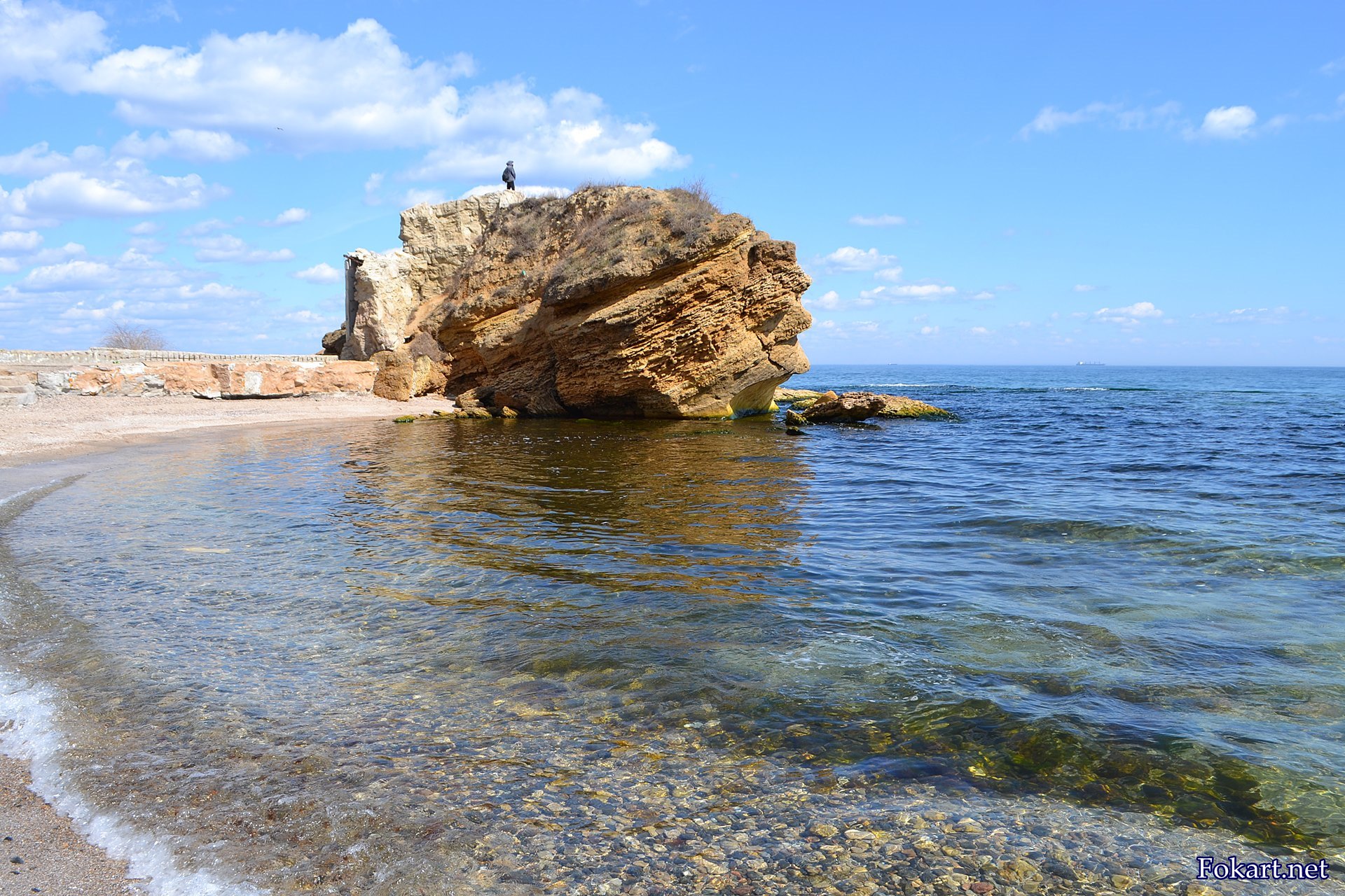 Чистая морская вода и большой жёлтый скалистый камень, фото