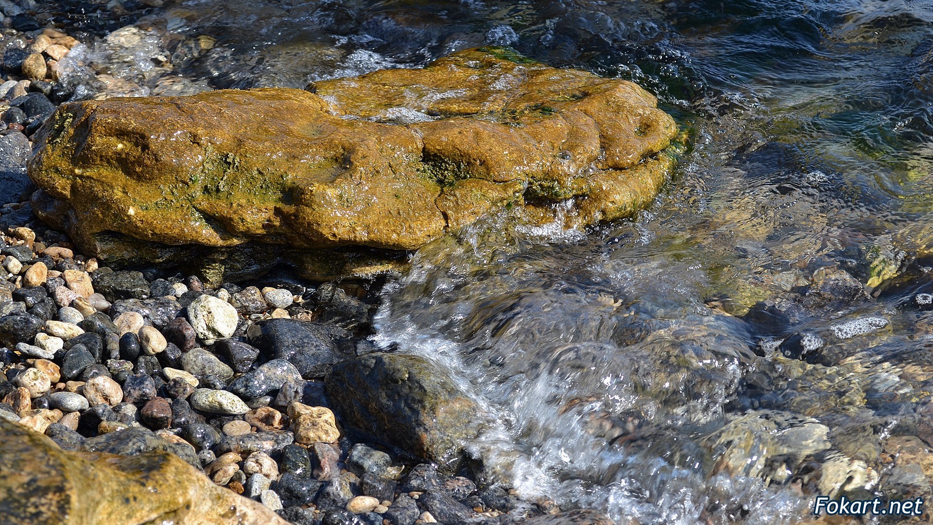 Чистая, прозрачная вода у каменистого берега, фото
